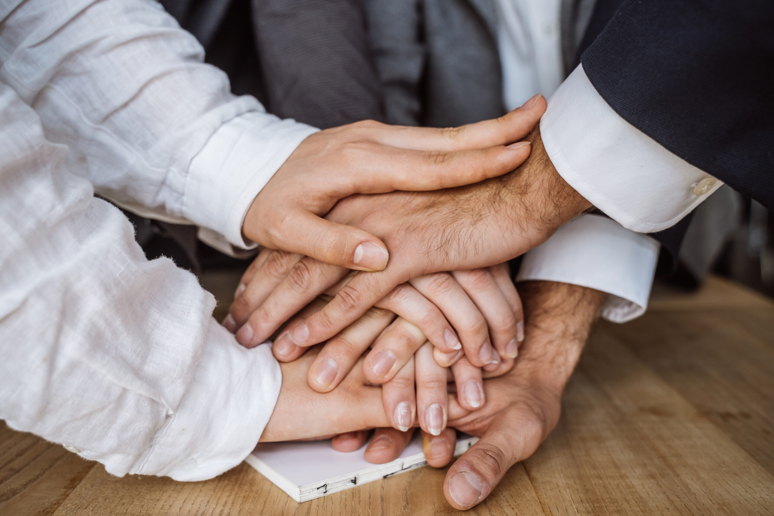 United hands of business team on workspace background. close view